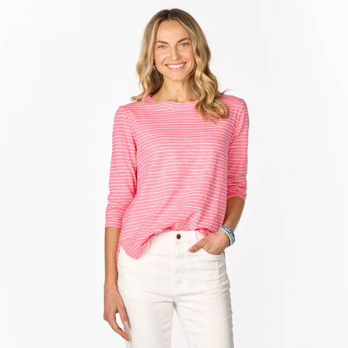 A woman with long blonde hair wears the Fresh Produce Clothes Ocean Stripe Catalina Top (Clearance) and white pants, smiling while standing against a plain white background.